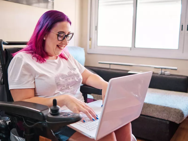 Disabled woman smiling while on laptop